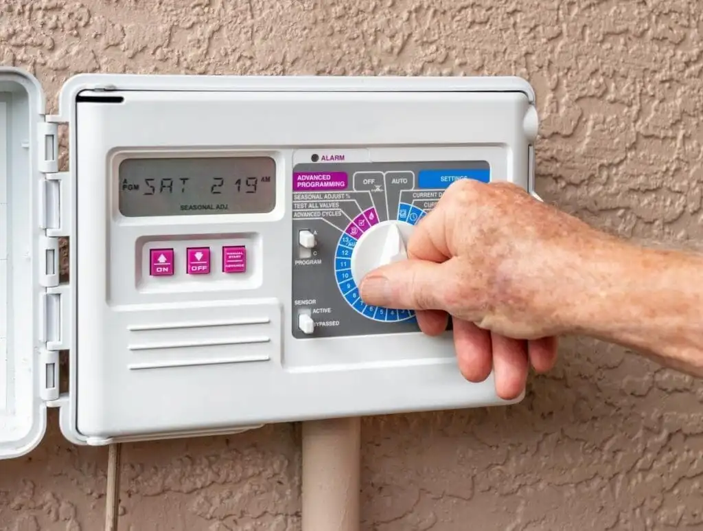 Adjusting a residential irrigation controller — the program dial controls which independent schedule you are editing