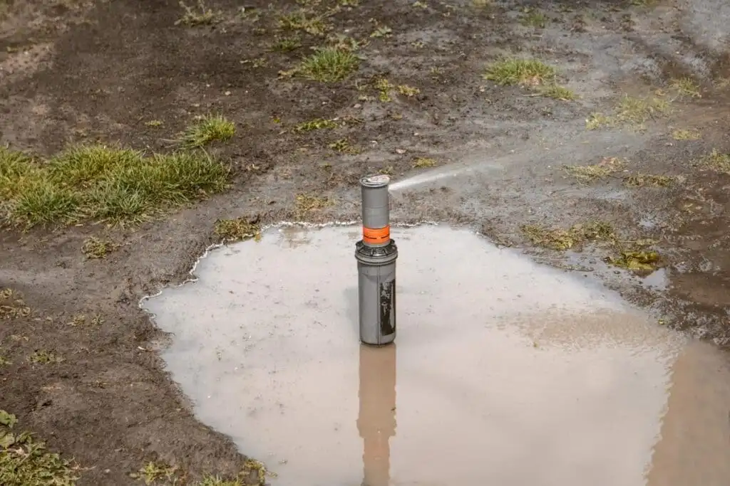 Active sprinkler line break creating a geyser in a residential lawn