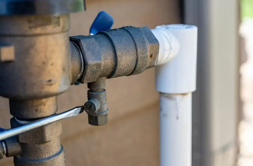 Backflow preventer assembly showing test cock port being accessed with a screwdriver