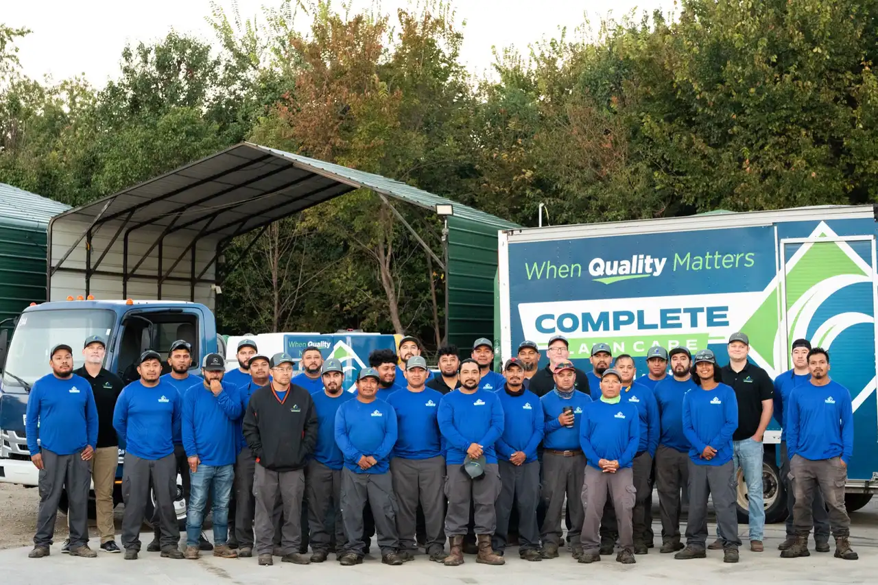 The Complete Lawn Care crew in front of the company trucks
