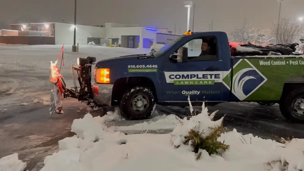 Complete Lawn Care plow truck clearing a snowy commercial parking lot