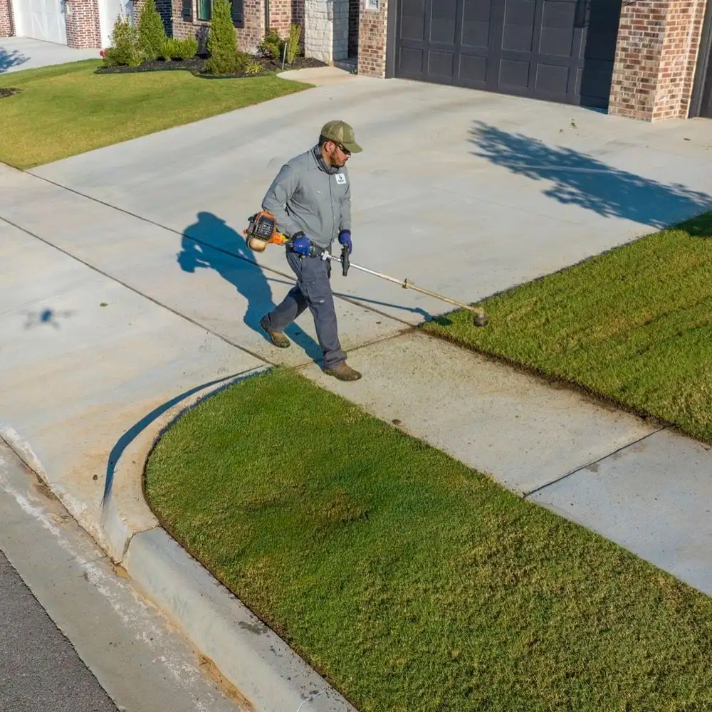 String-trimming a driveway edge for a clean finish