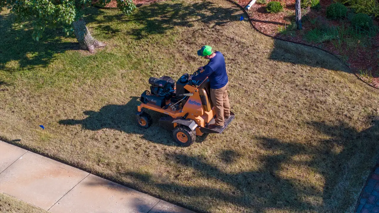 Complete Lawn Care technician core aerating a residential lawn