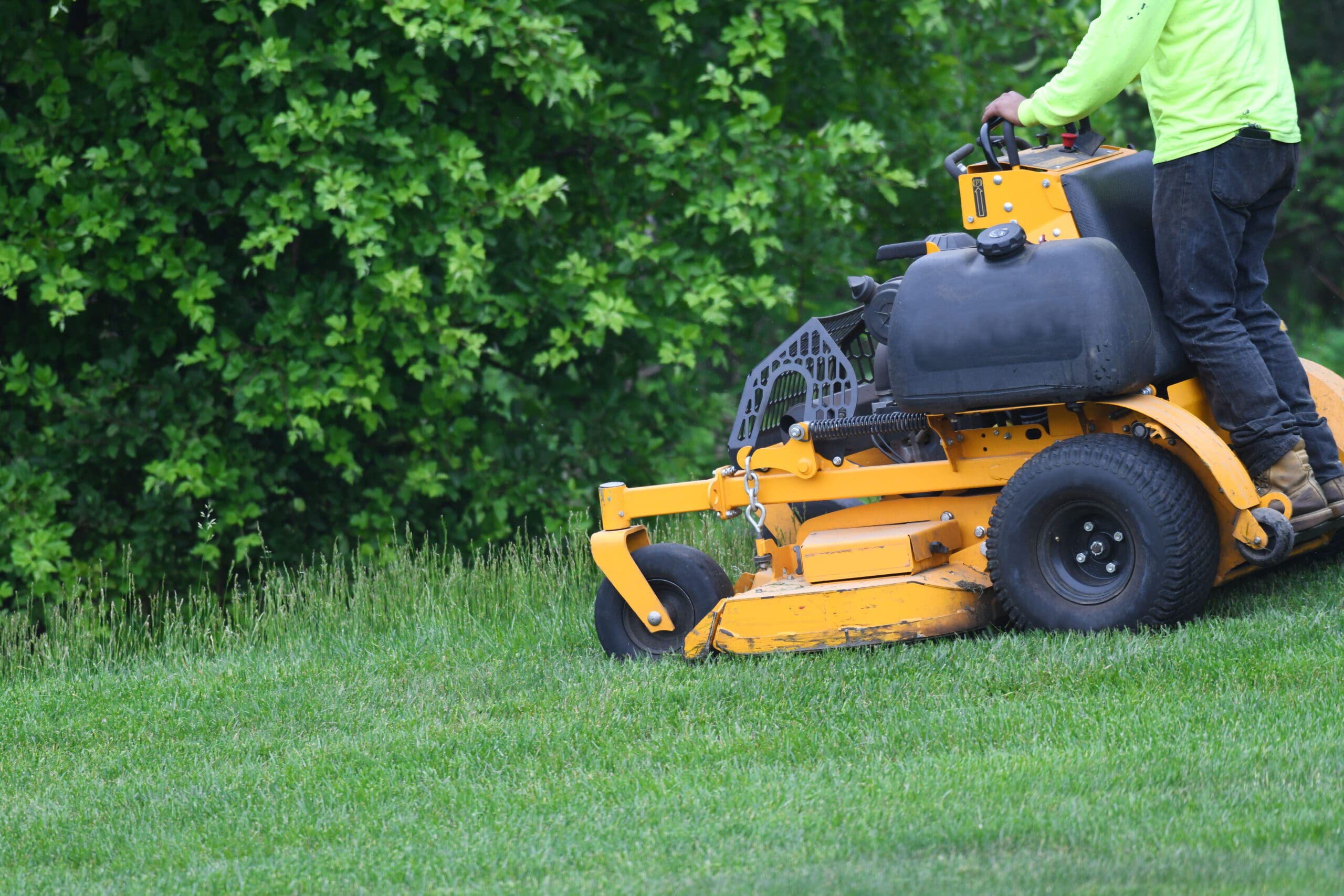 Mower cutting a Tulsa metro Bermuda lawn at the proper raised summer height